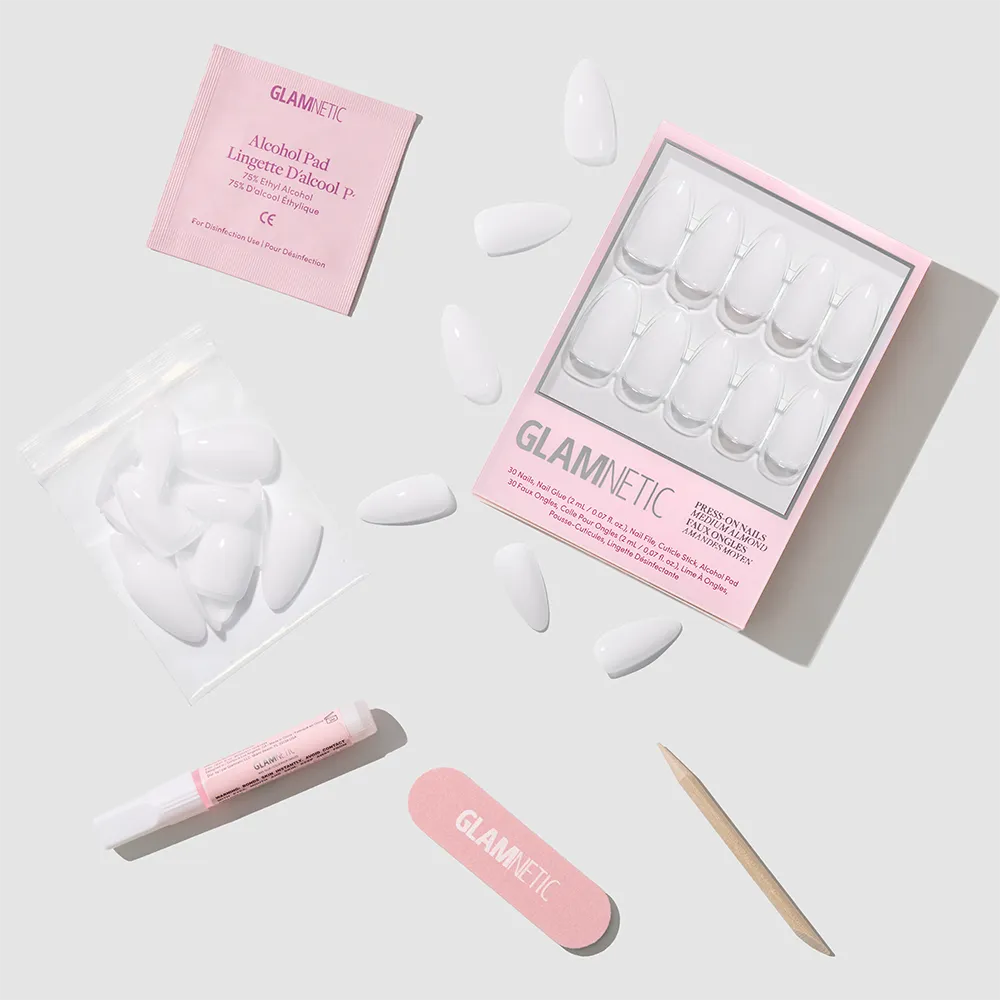 Clouded by glamnetic: elegant, almond-shaped milky mani press-on nails with extra nails, alcohol pad, nail glue, file, and cuticle stick—neatly arranged on a light gray background. Packaging features "glamnetic" in pink. - Product image