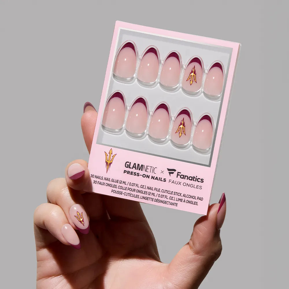 A hand holds the glamnetic Arizona State Sun Devils Press-On Nail Set, featuring salon-quality pink nails with maroon French tips and a gold ASU pitchfork logo on one nail.