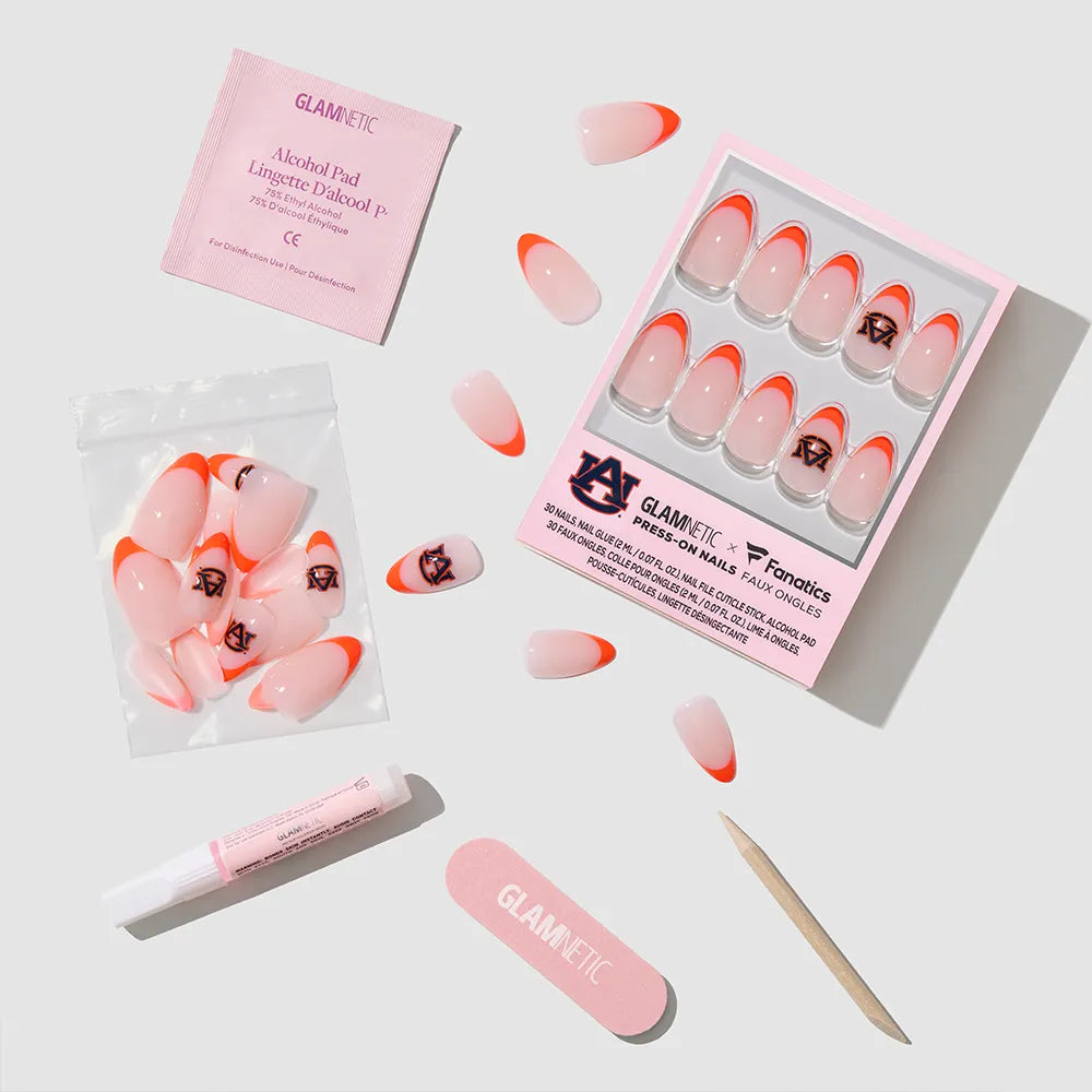 The glamnetic Auburn Tigers Press-On Nail Set includes orange-tipped nails with team logo art, nail glue, an alcohol pad, nail file, cuticle stick, and extra nails—all displayed on a white background. - Product image