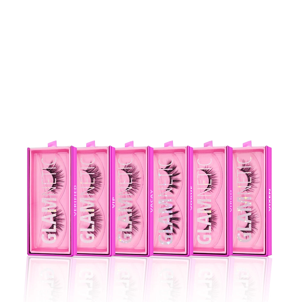Six pink rectangular boxes of glamnetic's Ultimate Lash Wardrobe are lined up, each with a clear lid showcasing voluminous black lashes inside. Both the boxes and the glamnetic brand name are prominently visible.