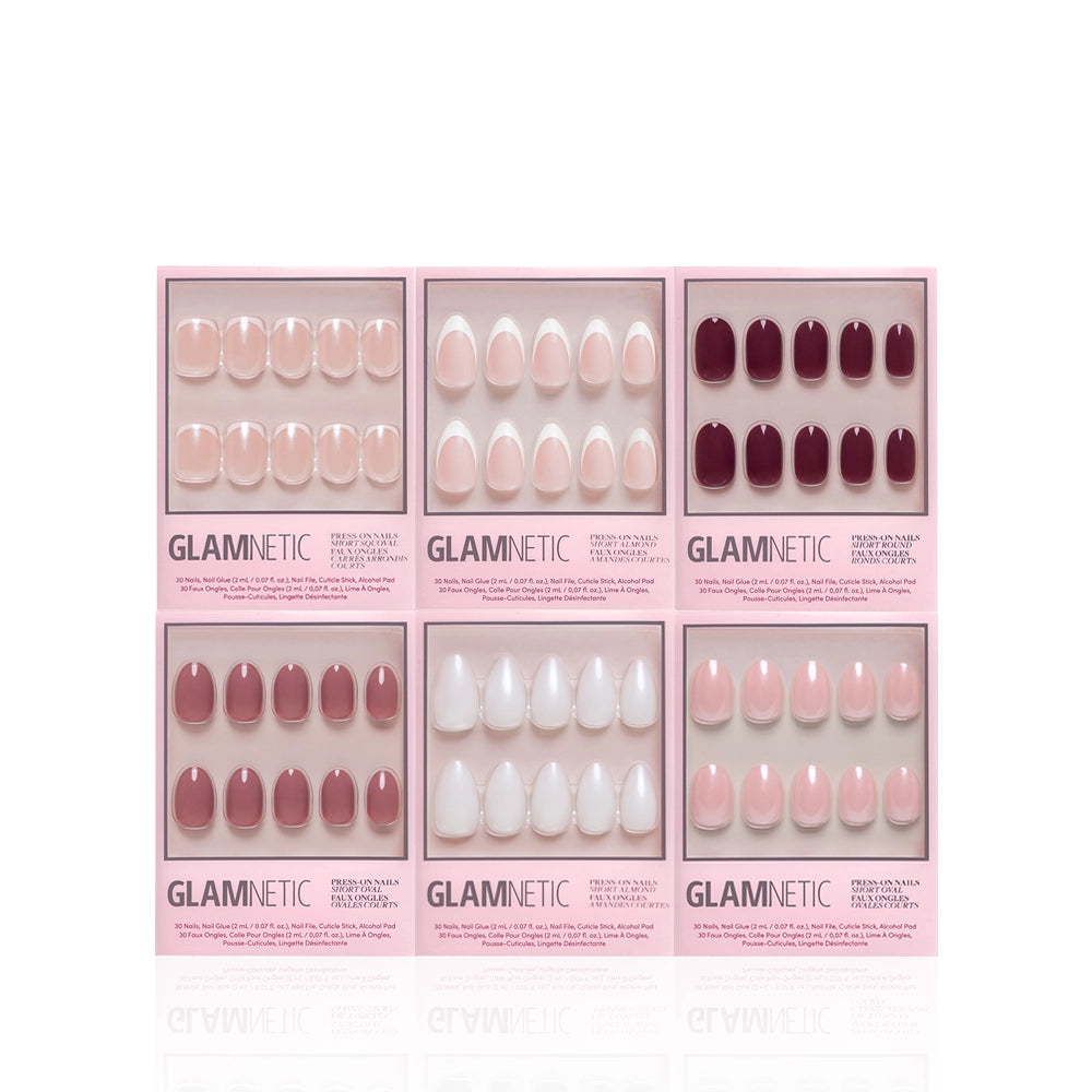Six boxes of glamnetic Clean Slate press-on nails are arranged in two rows, showcasing salon-quality designs in pink, nude, white, and burgundy. Each set is displayed in clear packaging with pink borders and glamnetic branding. - Product image