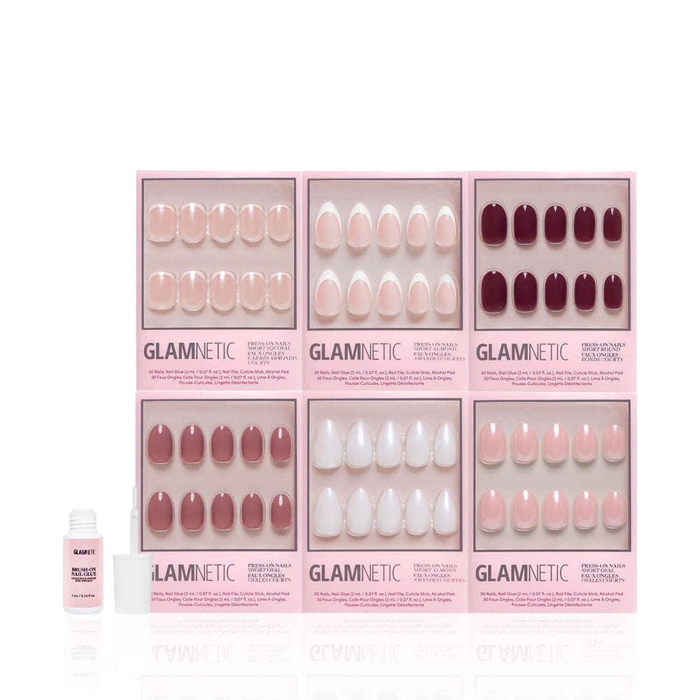 Six sets of glamnetic Clean Slate press-on nails in pink and burgundy shades are arranged in two rows, displaying salon-quality manicures and trendy designs. A nail glue bottle is placed to the left on a white background. - Product image