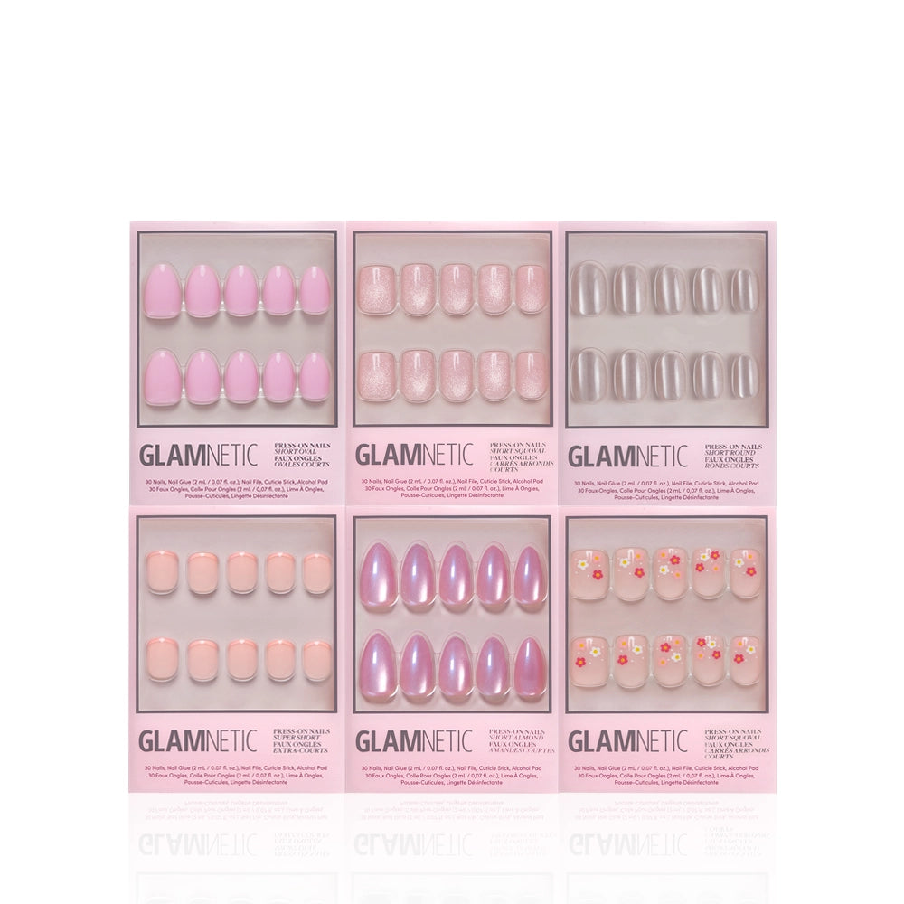 Six boxes of glamnetic Pink Intentions salon-quality press-on nails, each in chic packaging with assorted pink and nude designs—solid, glitter, and floral—are displayed upright in two rows on a white background. - Product image