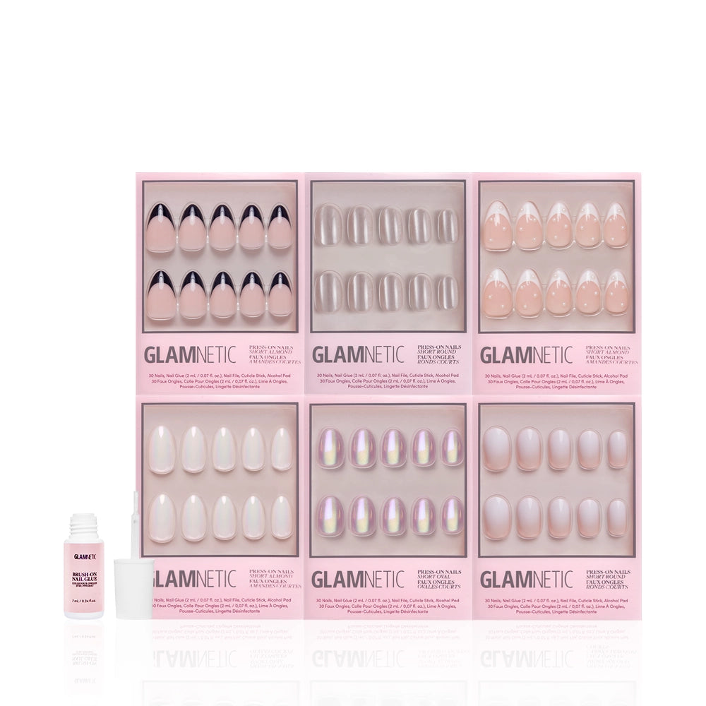 Six boxes of glamnetic Pearly Pick-Me-Ups press-on nail sets in nude and iridescent designs are arranged in two rows, with a small nail glue bottle in front on the left. The pink boxes feature clear windows displaying the nails. - Product image
