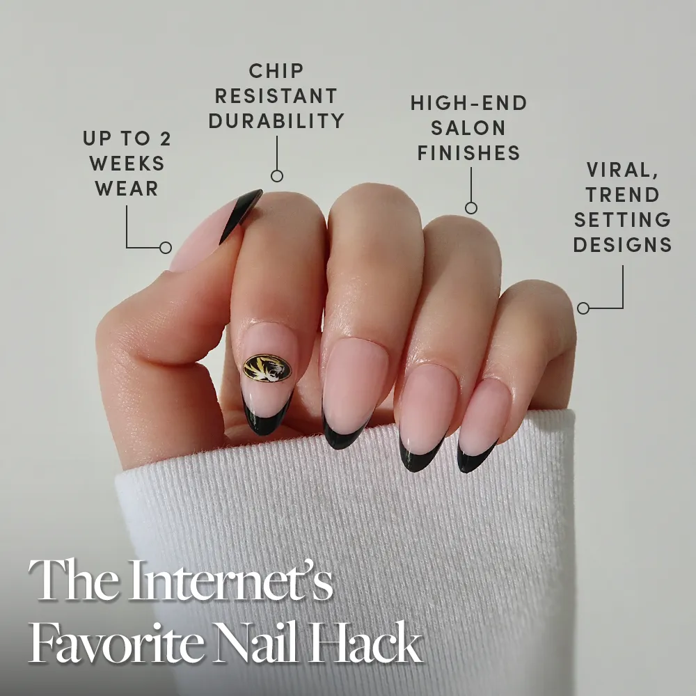 A hand with black French tips and a gold accent, inspired by the glamnetic Missouri Tigers Press-On Nail Set, is shown in a white sleeve. Features: up to 2 weeks’ wear, chip resistance, high-end finishes, and viral trend-setting designs. - Product image