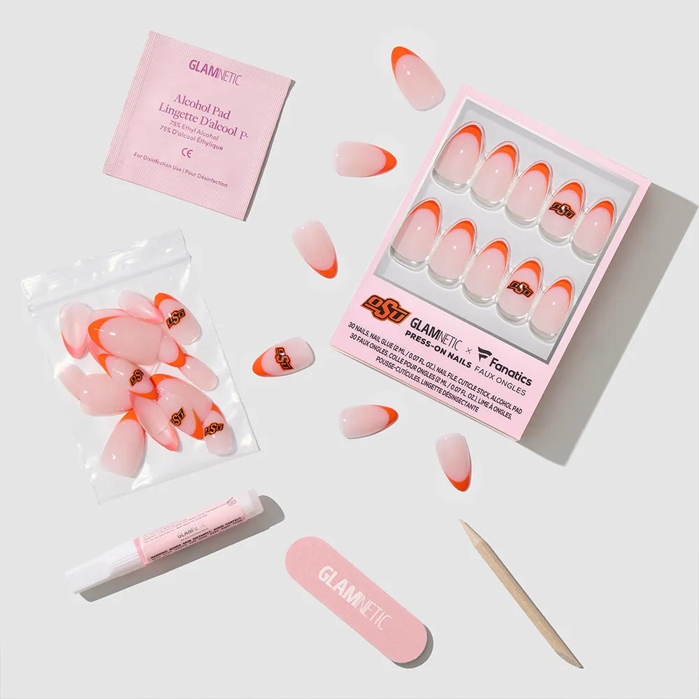 Show off your game day style with the glamnetic Oklahoma State Cowboys Press-On Nail Set, featuring pink and orange tips. Each set includes a nail file, cuticle stick, adhesive tube, alcohol pad, and extra nails on a white background. - Product image