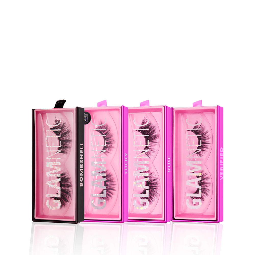Four boxes of glamnetic false eyelashes from the Viral at Midnight Bundle, in pink packaging, are arranged in a row. Each box displays a unique style name—Bombshell, Lucky, Vibe, and Verified—in clear front windows.