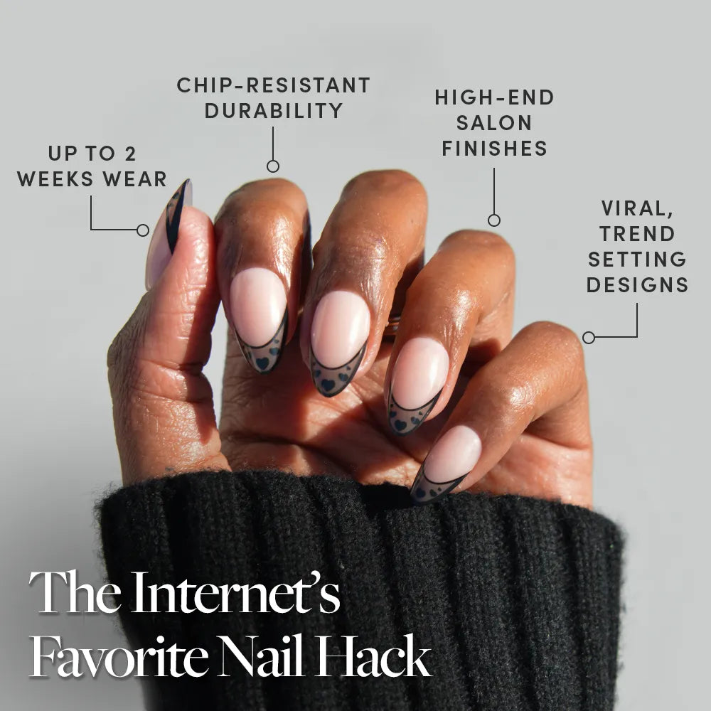 A hand with short almond nails features glamnetic's Love Noir: black heart nail art and chic French tips. Enjoy up to 2 weeks wear, chip-resistant, high-end finishes, and trendy designs. The Internet’s Favorite Nail Hack. - Product image