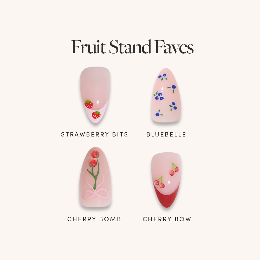The glamnetic Fruit Stand Faves set features four nail art designs: Strawberry Bits with berry accents, Bluebelle with blue flowers, Cherry Bomb with cherries and a bow, and Cherry Bow with cherries and bold French tips.