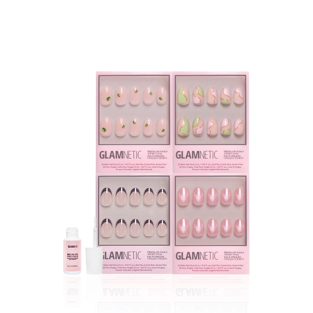 Four sets of glamnetic Sweet Sips pink press-on nails with glossy finish are displayed in pink boxes. A small open nail glue bottle with brush is in front. The white background highlights each short oval set's unique design. - Product image