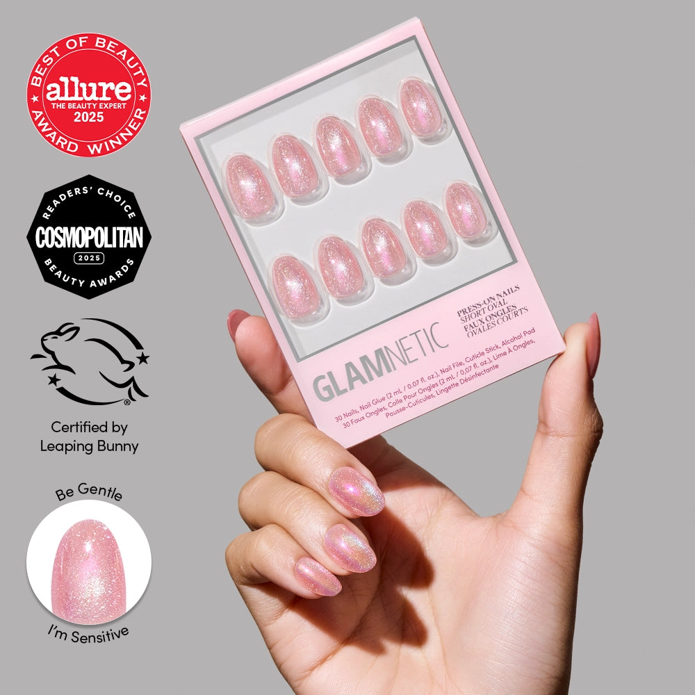 A hand with sparkly pink short oval press-on nails holds a matching glamnetic Guava Drop nail set box. To the left, beauty award badges and icons for “Certified by Leaping Bunny,” “Be Gentle,” and “I’m Sensitive” are displayed.