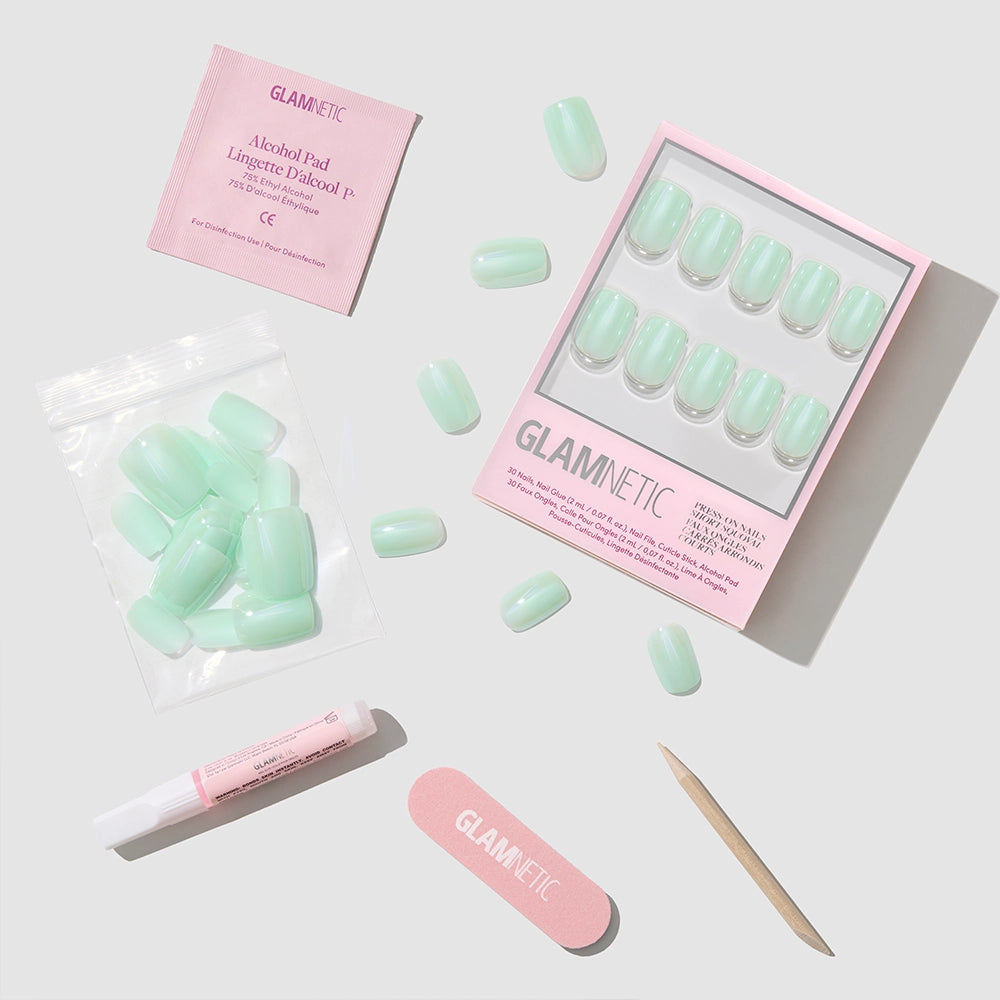 The glamnetic Honeydewy kit includes mint green vegan, cruelty-free press-on nails, glue, nail file, cuticle stick, alcohol pad, and extra nails—all displayed on a light gray background. - Product image