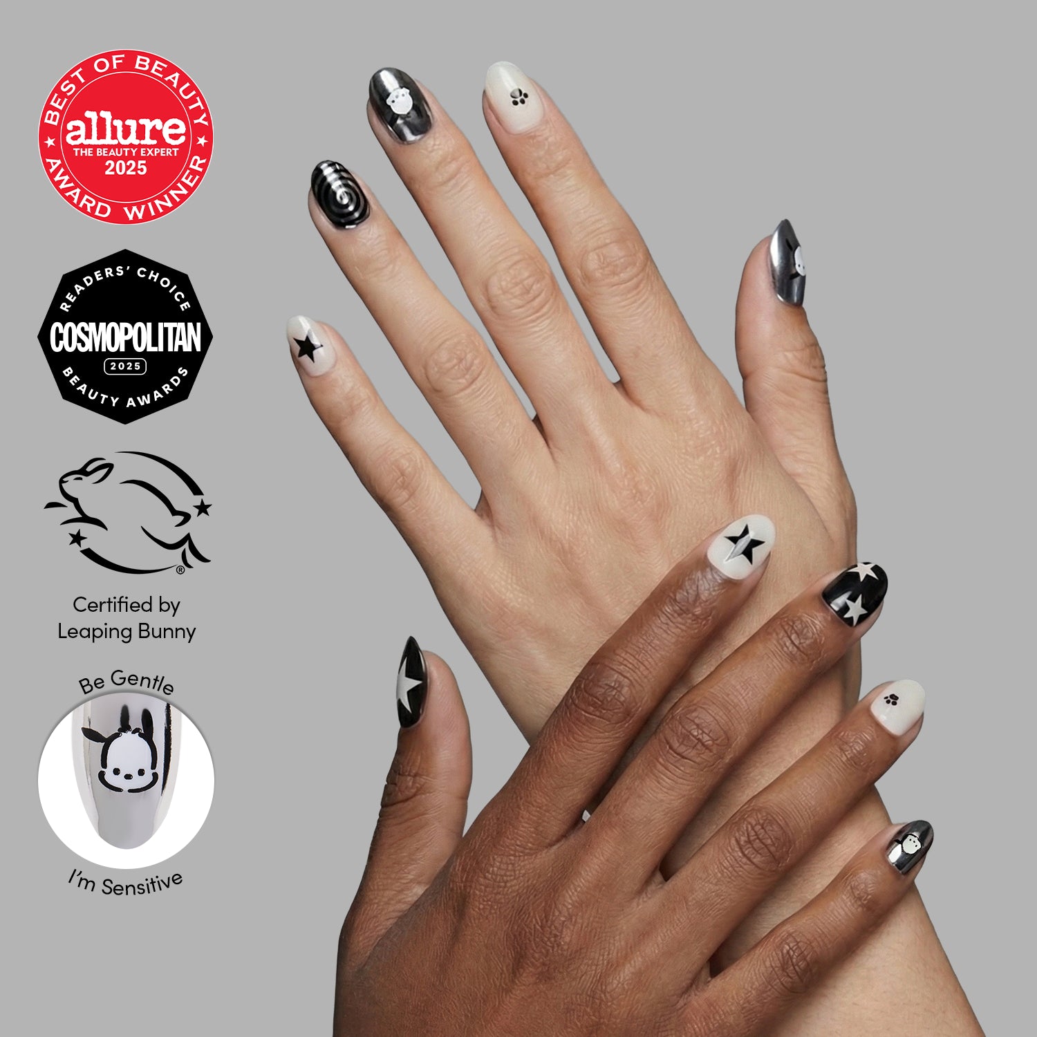 Two hands with manicured short oval nails feature glamnetic's Pochacco™ press-ons in black, white, and gray with stars and geometric art. Award and cruelty-free certification logos appear on the left side of the image. - Product image