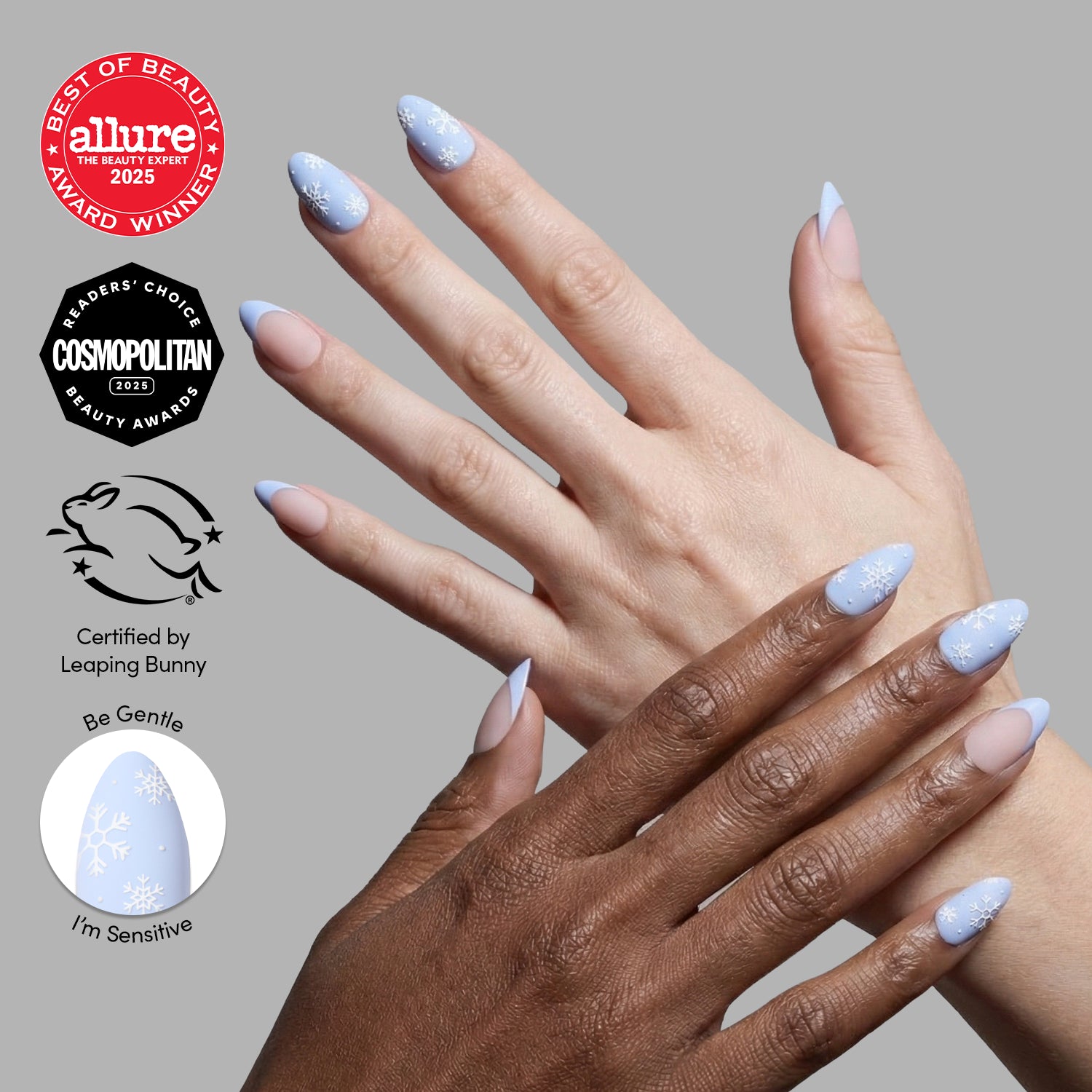 Two hands with long, almond-shaped Snow Bunny nails by glamnetic in light blue display white snowflake designs—perfect for winter. Beauty award badges and a Leaping Bunny cruelty-free certification appear on the left side.