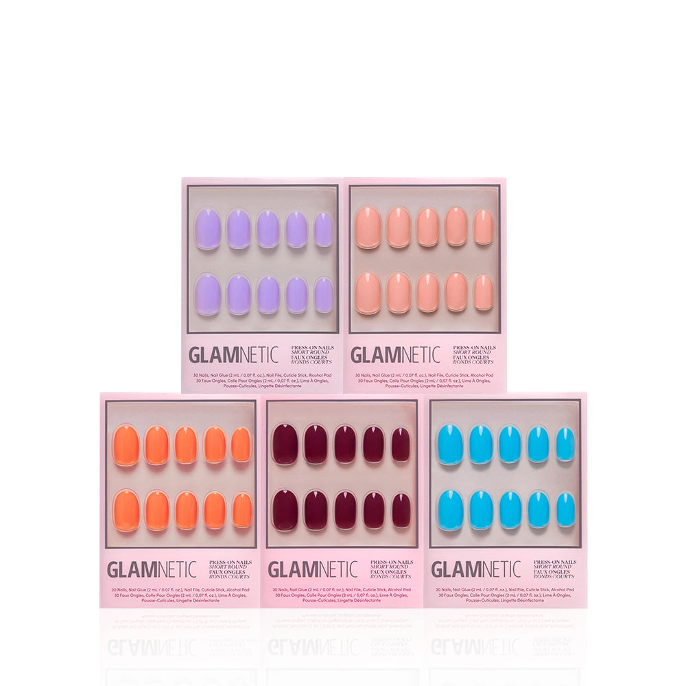 Five boxes of glamnetic Spring Round Up short round nails are shown, each with ten glossy nails in lavender, peach, orange, burgundy, and bright blue shades. The pink packaging is set against a white background. - Product image