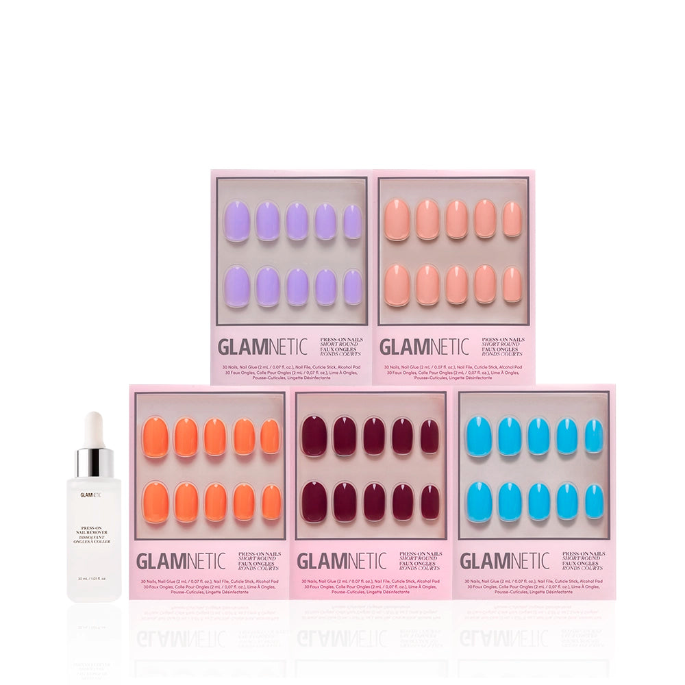 Five pink boxes of glamnetic’s Spring Round Up press-on nails display short round glossy nails in lavender, peach, coral, burgundy, and bright blue. A white Glamnetic dropper bottle stands to the left of the nail sets. - Product image