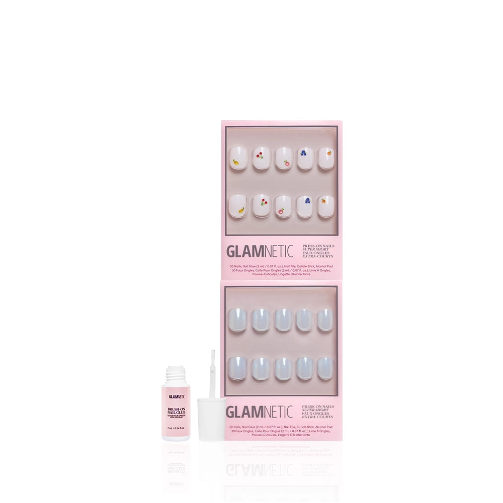 The glamnetic Short & Suite press-on nails set includes two trays of pastel and heart design artificial nails in pink packaging, plus a small bottle of nail glue with cap and applicator brush. - Product image