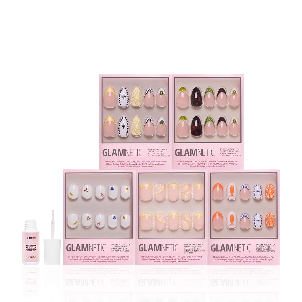 Six boxes of glamnetic Taste of Europe press-on nails, with pastel and 3D fruit designs, are arranged in two rows. A small open bottle of nail glue with a brush is placed to the left, all on a white background. - Product image