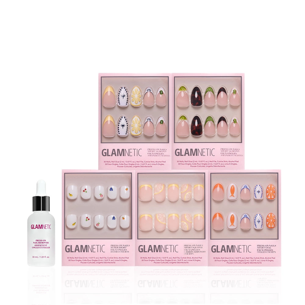 Six sets of glamnetic Taste of Europe press-on nails, featuring Mediterranean and 3D fruit designs, are displayed in pink art boxes. A small glamnetic nail glue bottle stands to the left against a white background. - Product image