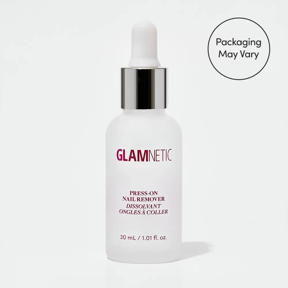 A white dropper bottle labeled glamnetic Press-On Nail Remover with pink and silver text sits on a white background. The acetone-free formula is gentle on natural nails, with a circle nearby stating Packaging May Vary. - Product image