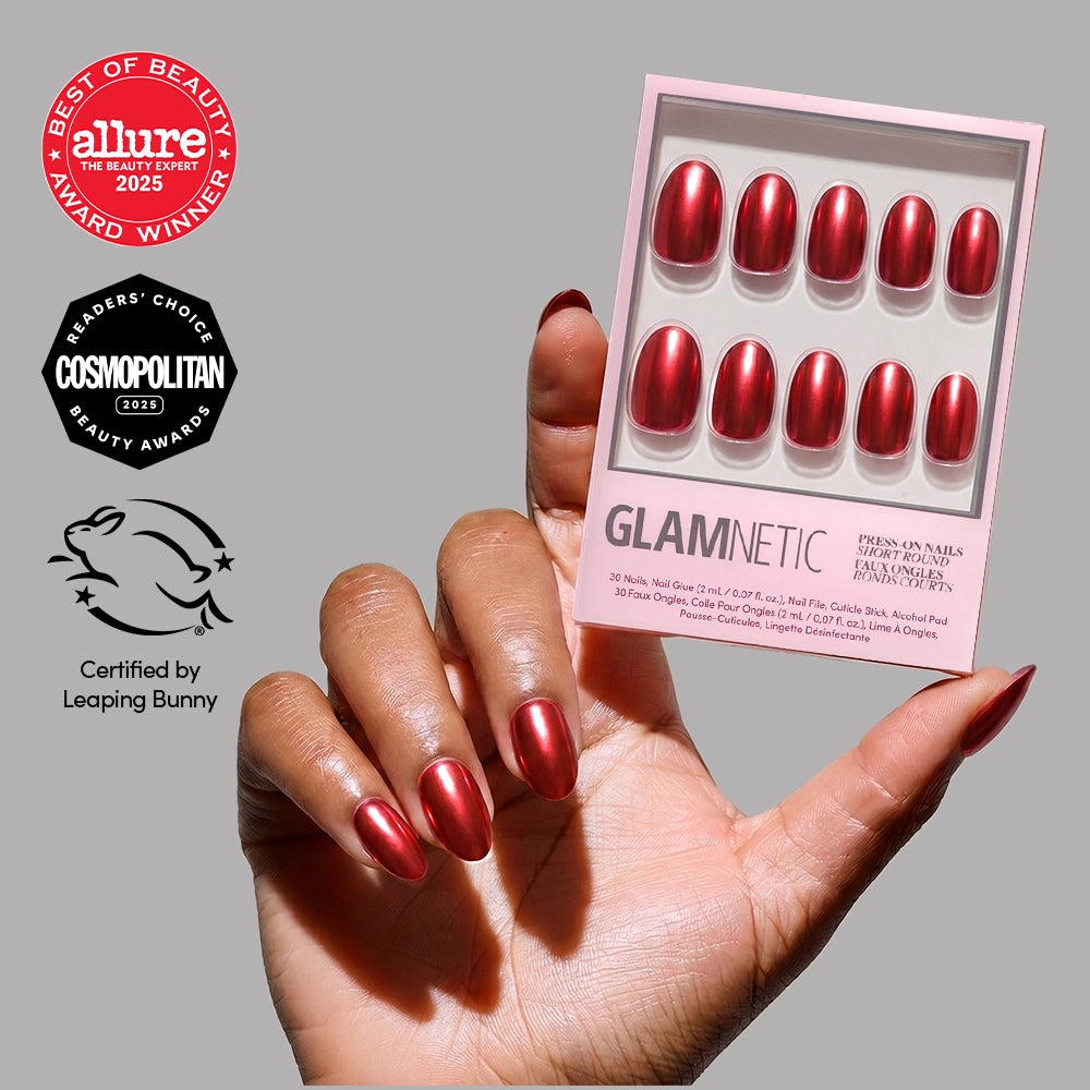 A hand with shiny red short round nails holds the glamnetic Cherry Glaze nail set. Allure, Cosmopolitan, and Leaping Bunny award badges appear on the left against a light pink background.