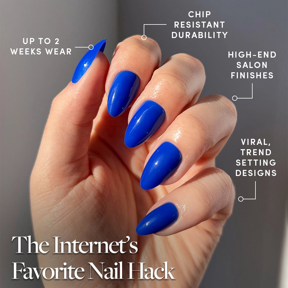 A hand shows off long, glossy Cobalt Blue nails by glamnetic in sunlight. Features include up to 2 weeks' wear, chip-resistant durability, high-end salon finish, and viral summer nail designs. - Product image