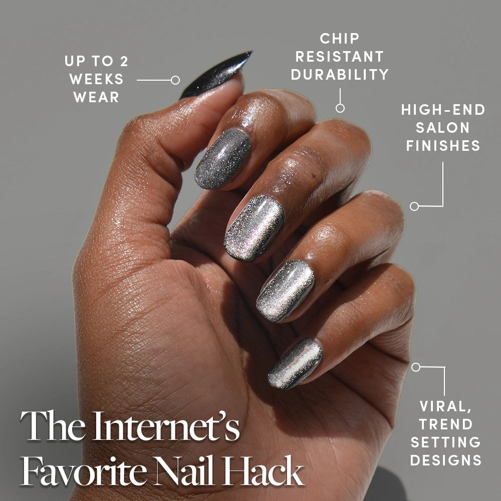 A hand with glamnetic's Galactic shiny silver metallic press-on nails is shown, featuring chip-resistant, salon-quality wear for up to 2 weeks and trend-setting designs. Text: The Internet’s Favorite Nail Hack. - Product image