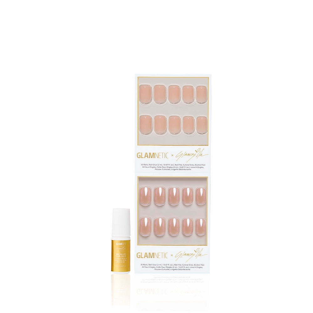 A set of glamnetic IN THE NUDE press-on nails in a short squoval shape is displayed in two rows inside clear packaging, with a small bottle of nail glue placed in front, all shown against a white background. - Product image