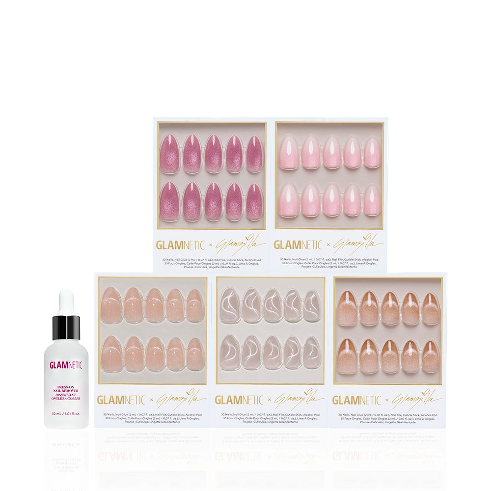 Five boxes of glamnetic STRICTLY VELVETS press-on nails in assorted pink and nude shimmer and almond styles are arranged in rows, with a bottle of glamnetic cuticle oil with dropper on the left. - Product image