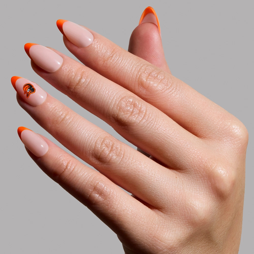 Show off your team spirit with glamnetic’s Baltimore Orioles Press-On Nail Set: chic almond nails in nude with orange tips, plus a detailed orange and black helmet design on the ring finger—perfect for Orioles fans!.