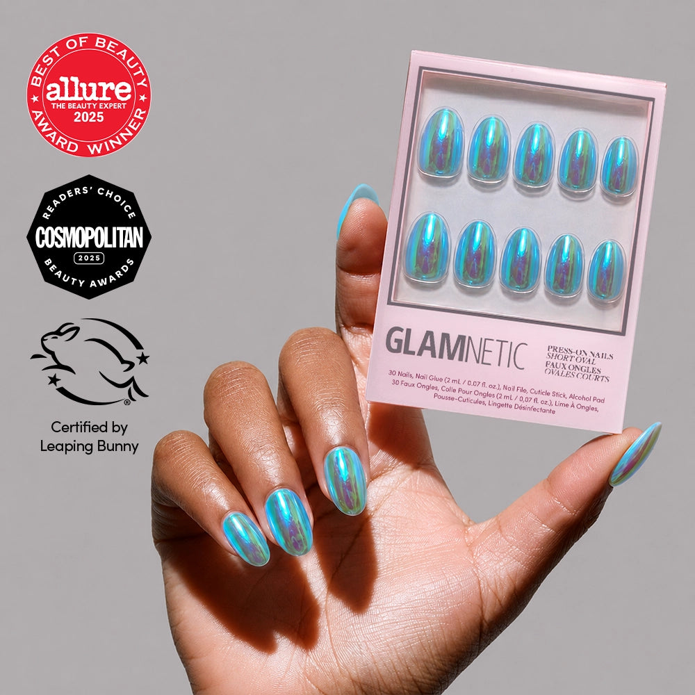 A hand with shiny, iridescent blue holographic press-on nails holds a glamnetic Siren Nail Set box, featuring Allure and Cosmopolitan award badges and a Leaping Bunny cruelty-free logo on the side.