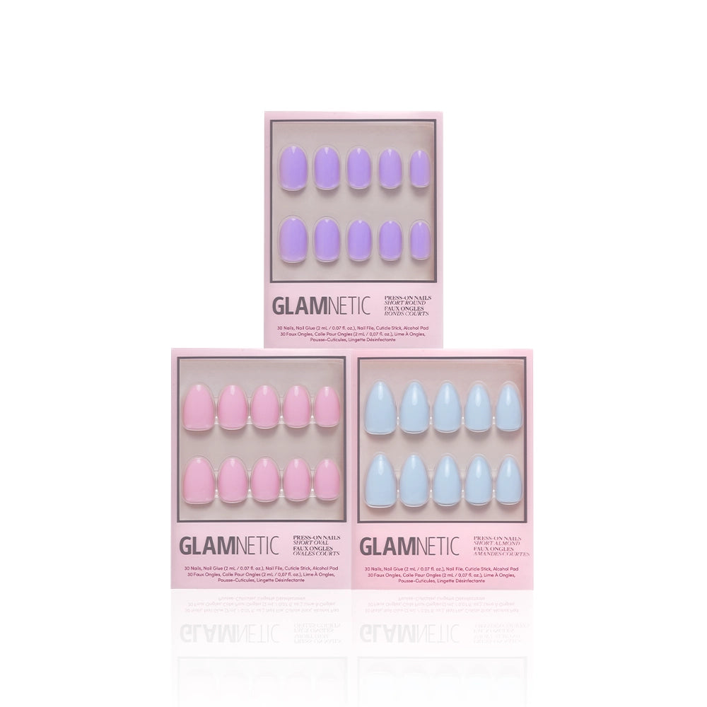 Three boxes of glamnetic Blooming Buds press-on nails in pastel lavender, pink, and blue are arranged on a white background. Each set includes short almond nails in ten sizes, neatly lined up in a row. - Product image
