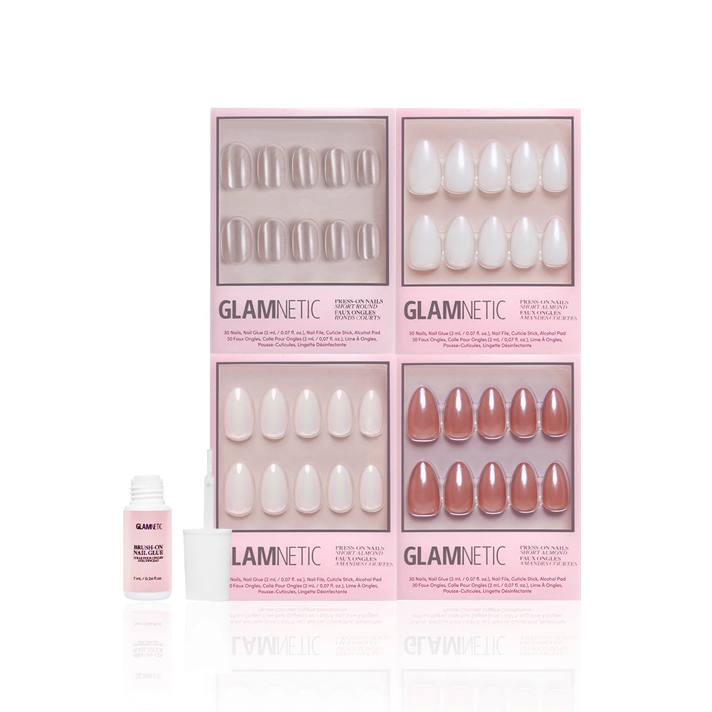 Four boxes of glamnetic Glaze It press-on nails in nude and pink shades, including a short almond set with assorted shapes, are arranged in a grid next to an open glamnetic nail glue bottle and cap on a white background. - Product image