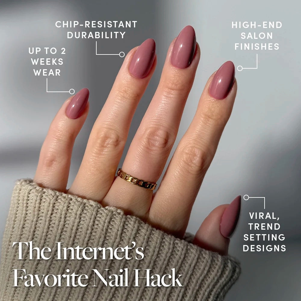 A hand displays glamnetic's Mauve Obsession vegan press-on nails—long, almond-shaped with viral designs, chip-resistant durability, high-end salon finish, and up to 2 weeks wear. The wearer also has a ring and beige sweater. - Product image