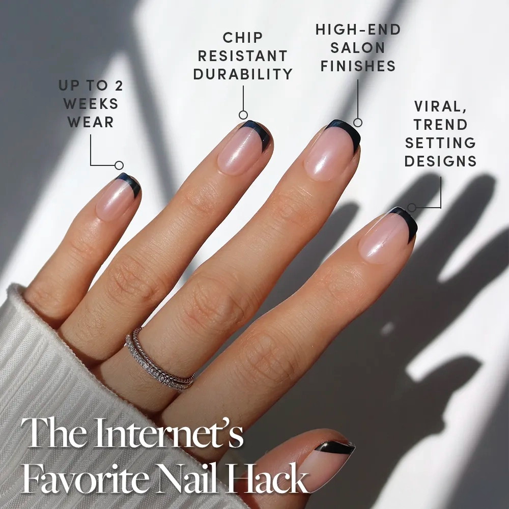 A hand with manicured short squoval nails in glamnetic’s Squid Ink features black French tips and a silver ring. Enjoy up to 2 weeks wear, chip-resistant durability, salon-quality finish, and viral trendsetting press-on nail design. - Product image