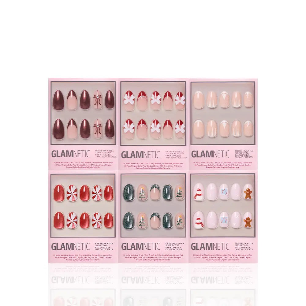 Six boxes of glamnetic All Decked Out winter press-on nails are arranged in two rows, displaying festive red, green, and white holiday designs with snowflakes, candy canes, Christmas trees, and gingerbread men for a cheerful look. - Product image