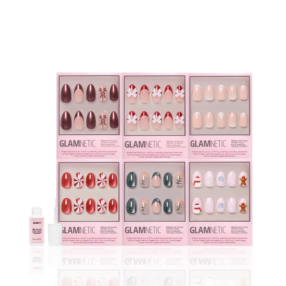 Get "All Decked Out" by glamnetic: six festive winter press-on nail sets in pink boxes, featuring holiday designs like candy canes, snowflakes, gingerbread men, classic red, and nude—plus nail glue included!. - Product image