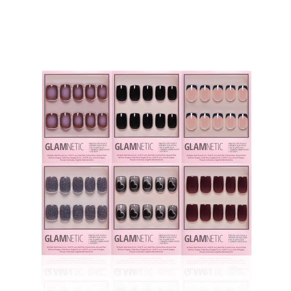 Six sets of glamnetic press-on nails, including the Back in Black Squovals and other designs in various colors, are arranged in two rows against a white background. Each set comes in pink packaging, featuring diverse nail shapes and finishes for salon-quality manicures at home. - Product image