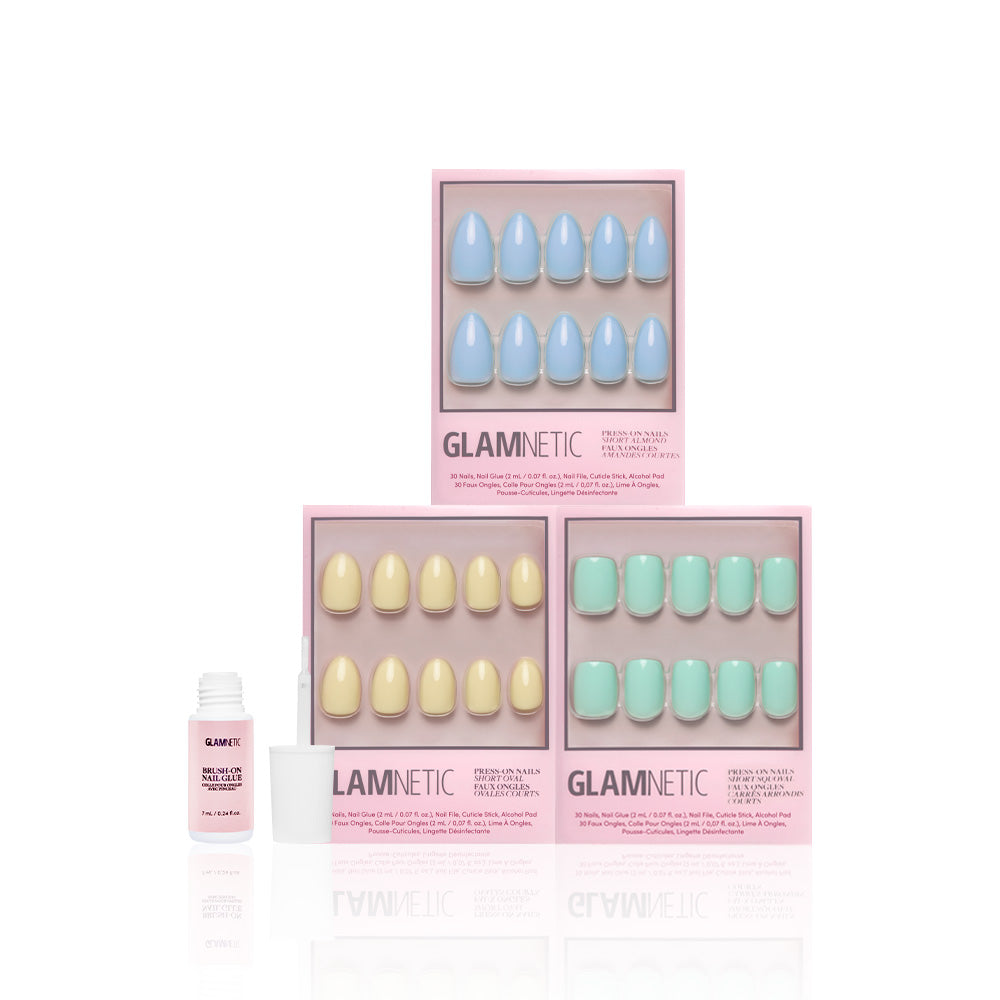 Three boxes of glamnetic’s Anns Palette press-on nails in pastel blue, yellow, and green are displayed—perfect for spring. An open glamnetic nail glue bottle with an applicator is shown to the left on a white background. - Product image