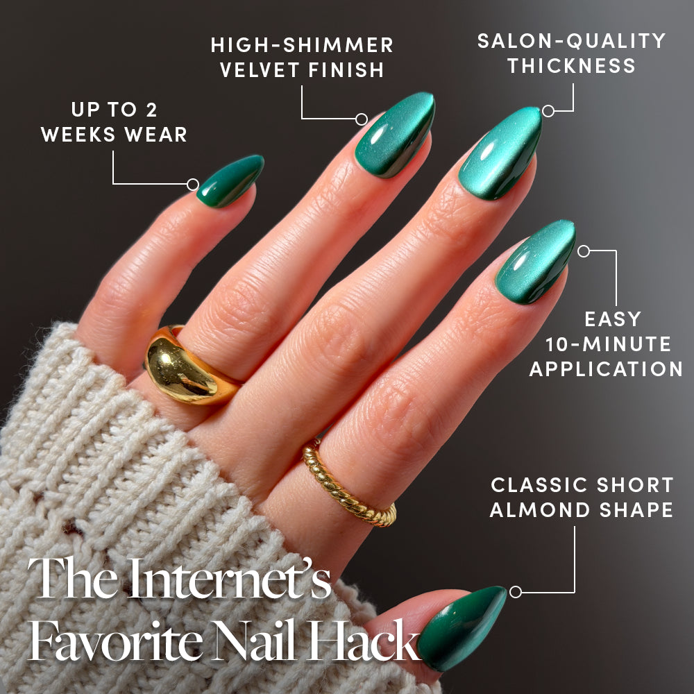 Arctic Aurora - A hand with short almond-shaped emerald green Arctic Aurora press-on nails by Glamnetic, surrounded by labels highlighting features such as two-week wear, salon-quality thickness, and easy application.