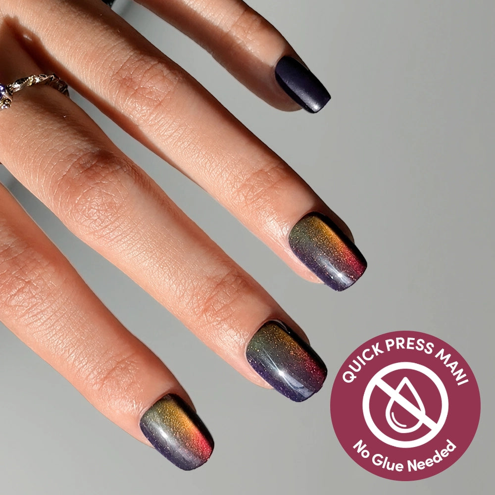 A hand displays square, multicolor gradient nails with a shiny finish, showcasing the vibrant glamnetic Aura Reading stick-on nails. At the bottom right corner, a circular “Quick Press Mani, No Glue Needed” label highlights the effortless Aura Reading Quick Press Mani experience.