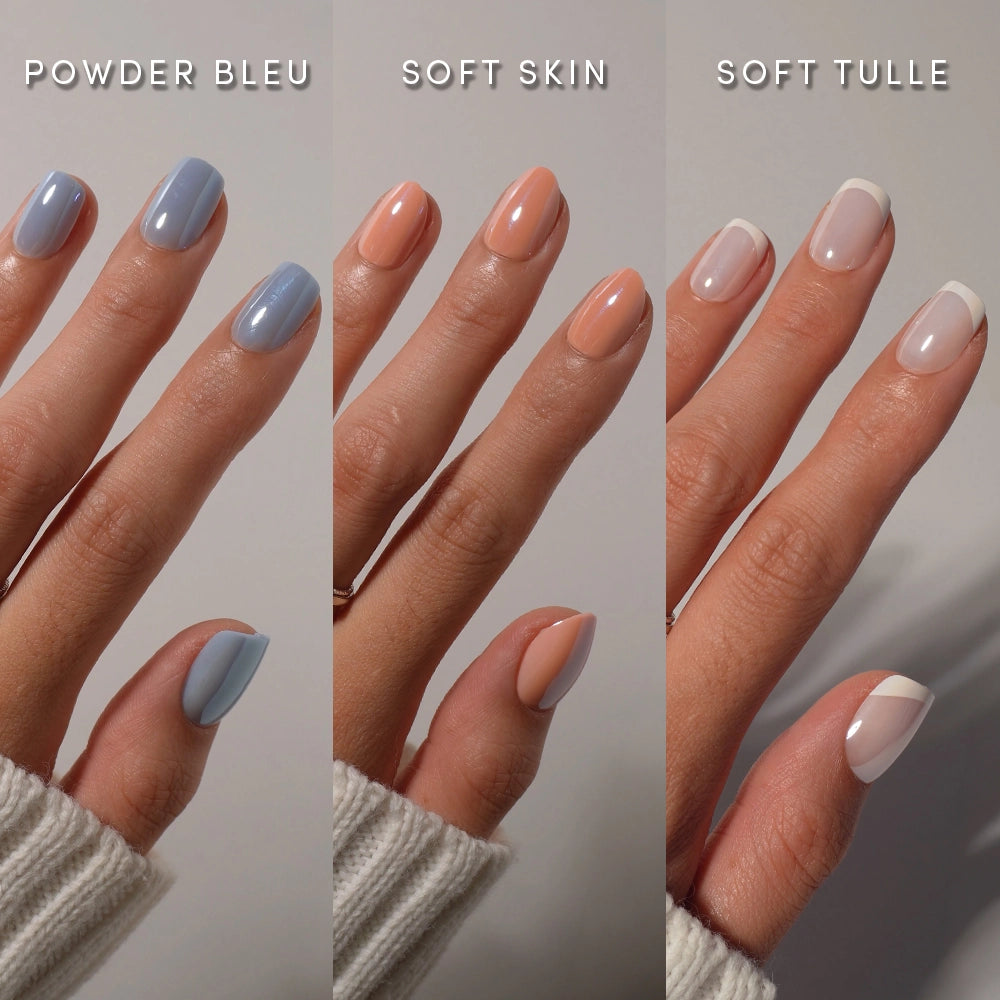 Three manicured hands display distinct nail looks from the glamnetic Routine Refresh Collection: powder blue, peachy soft skin, and sheer nude Soft Tulle with white tips—all on short, almond-shaped nails. Each style boasts a flawless, salon-quality finish that perfectly showcases these effortless press-on nails. Cozy sweater cuffs are visible on each hand. - Product image