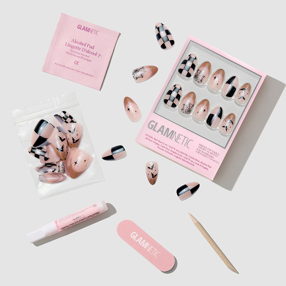 Set of GLAMNETIC Bat Check Press-On Nail Set in pink and black patterns, featuring salon-quality mani short almond press-on nails, nail glue, cuticle stick, nail file, alcohol pad, and extra nails—all arranged neatly on a light gray background. - Product image