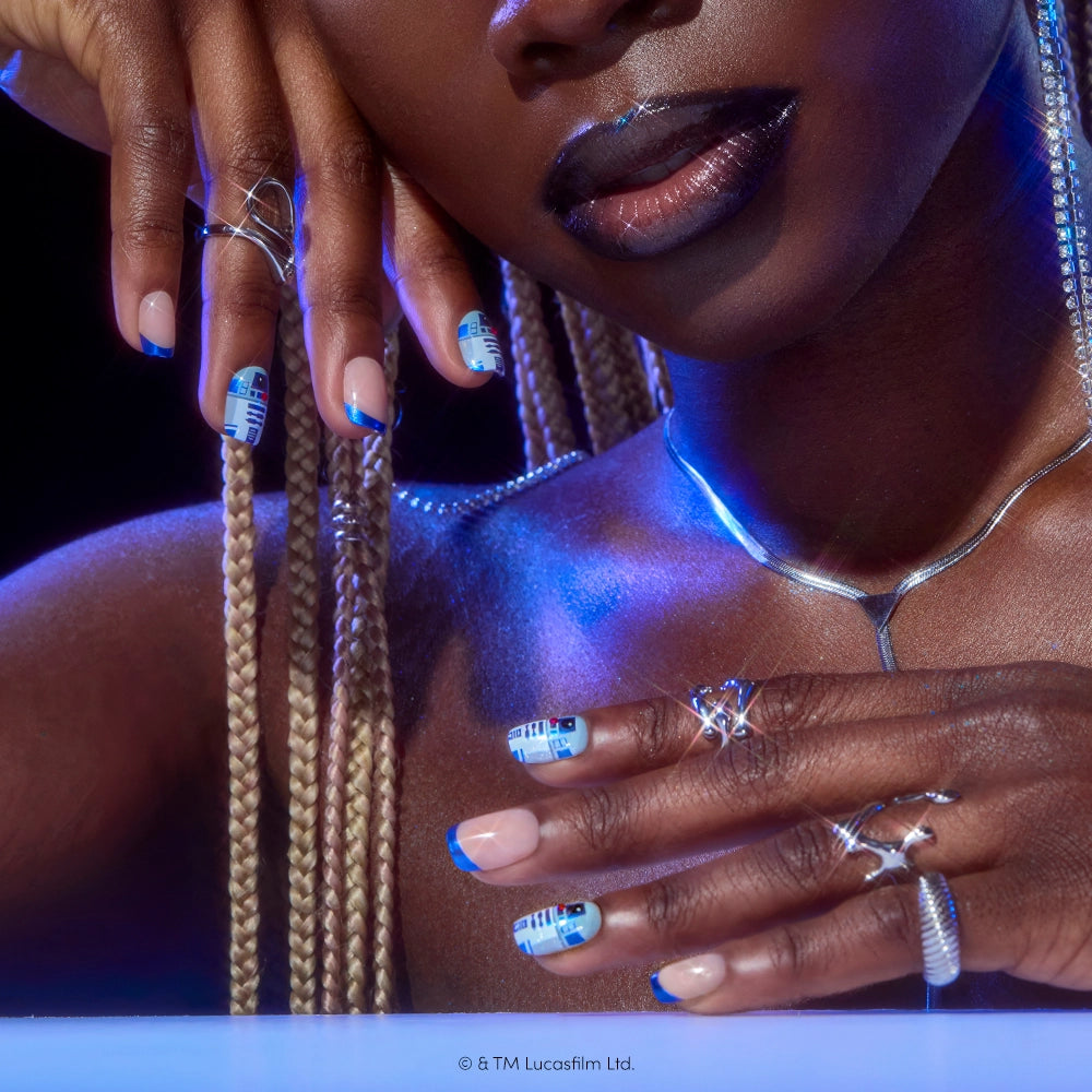 A person with long braids shows off glamnetic’s Beep-Boop nails, silver rings, and a silver necklace, with blue lighting enhancing the sci-fi-inspired look. The Beep-Boop press-on nails by glamnetic and shimmering accessories create a strikingly futuristic style. - Product image