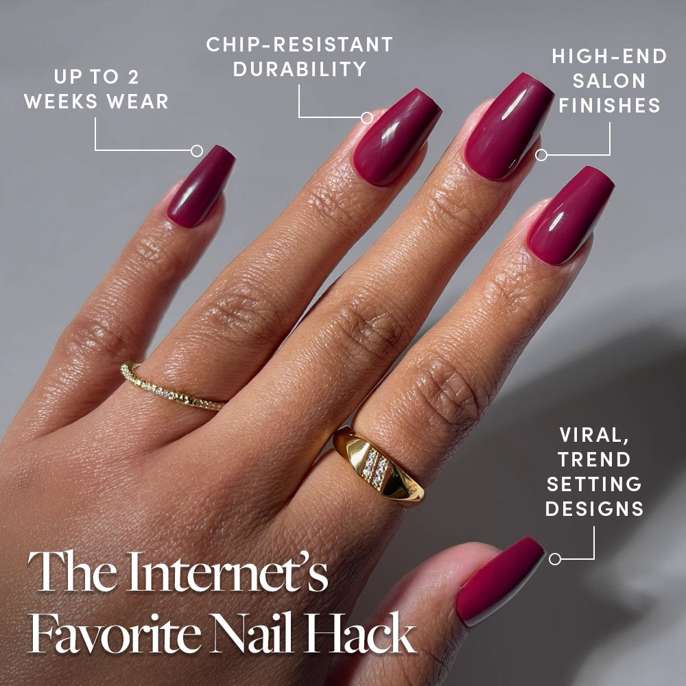 A hand flaunts glamnetic's Berry Fierce—long, glossy maroon coffin nails—against a neutral backdrop. Text notes chip-resistant durability, luxe finish, up to 2 weeks’ wear, and trendy style. Two gold rings accent the look. - Product image