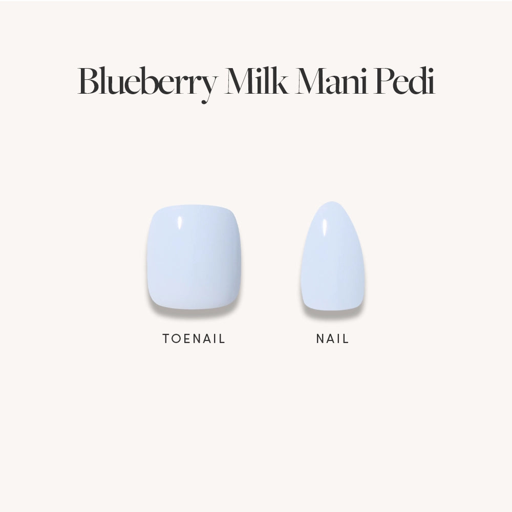 The glamnetic Blueberry Milk Mani &amp; Pedi set showcases short almond-shaped press-on nails in a light pastel blue, with a matching fingernail and toenail displayed against a beige background.