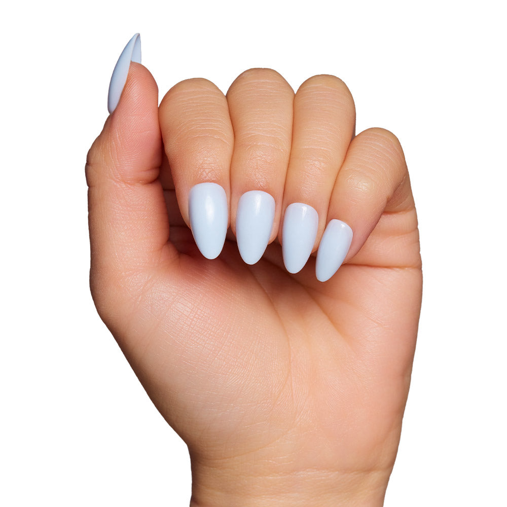 A hand with short almond-shaped nails painted in glossy light blue, like the Blueberry Milk set by glamnetic, fingers gently curled inward against a plain white background. - Product image
