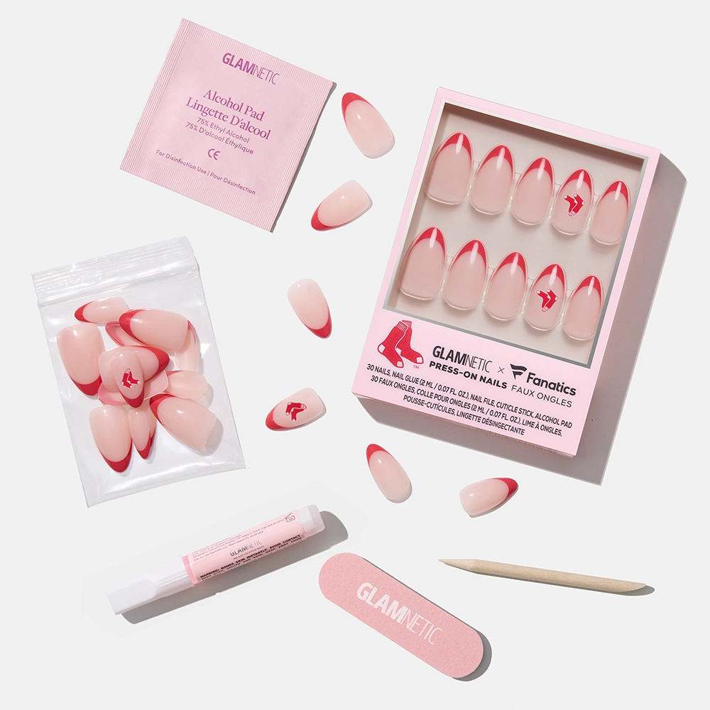 The glamnetic Boston Red Sox Press-On Nail Set features pink nails with red tips and the team logo, displayed on a white background with a file, cuticle stick, adhesive, alcohol pad, and nails both in and out of the box. - Product image