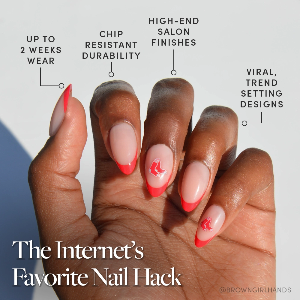 A hand with almond-shaped nails featuring a pink base and bold red tips, some with red designs. Showcasing the glamnetic Boston Red Sox Press-On Nail Set: salon quality, chip-resistant, trendy designs, up to 2 weeks wear. - Product image