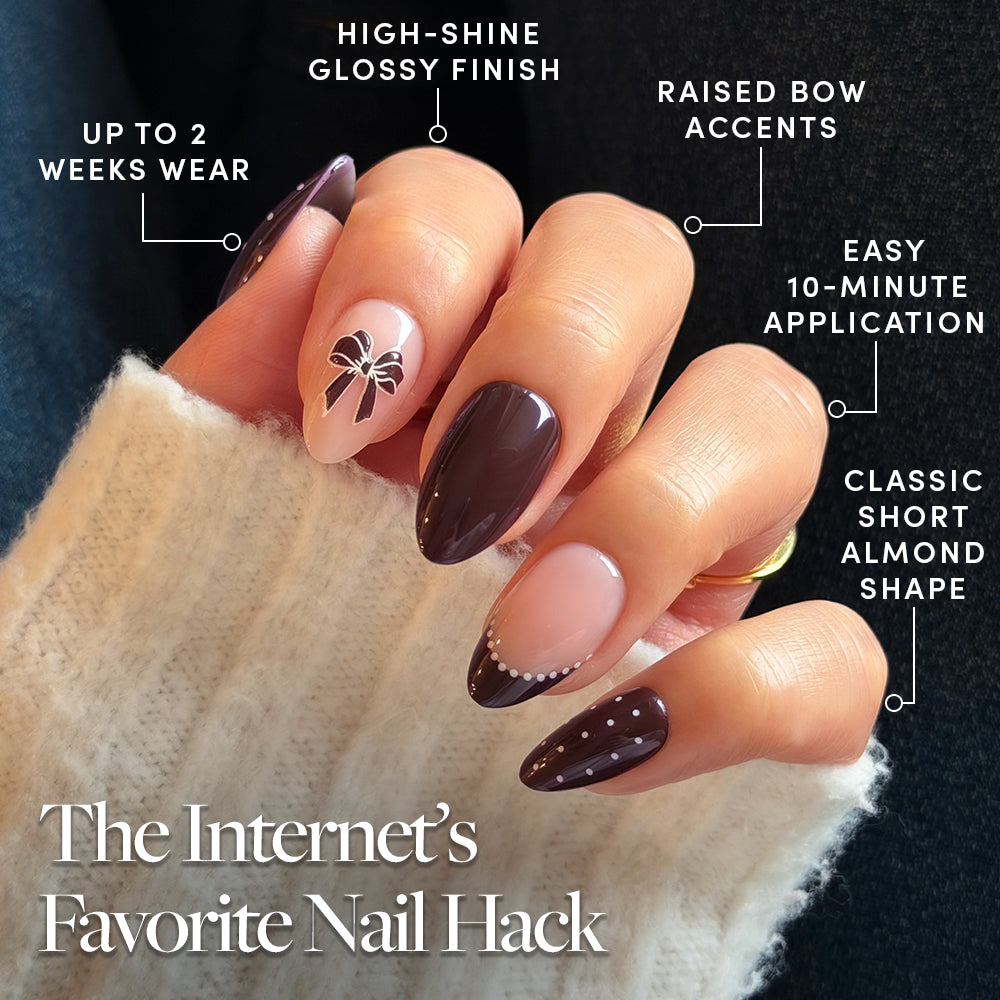 Glamnetic Bow Season short almond nails in chocolate brown, featuring a bow decal on one finger, white polka dots on another, a glossy finish, and two-week wear. - Product image
